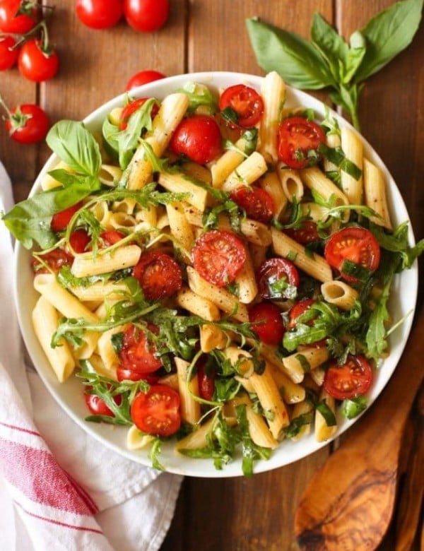 Tomato & Arugula Balsamic Pasta Salad surrounded by fresh ingredients